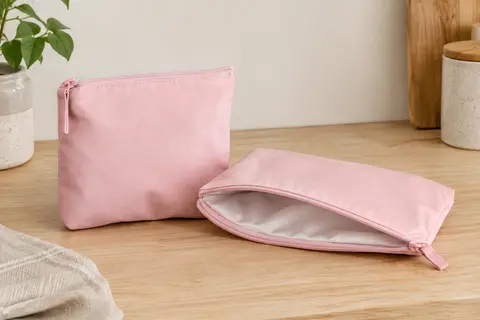 Deux pochettes à goûter rose pastel, carrée et rectangulaire, avec fermeture zippée.